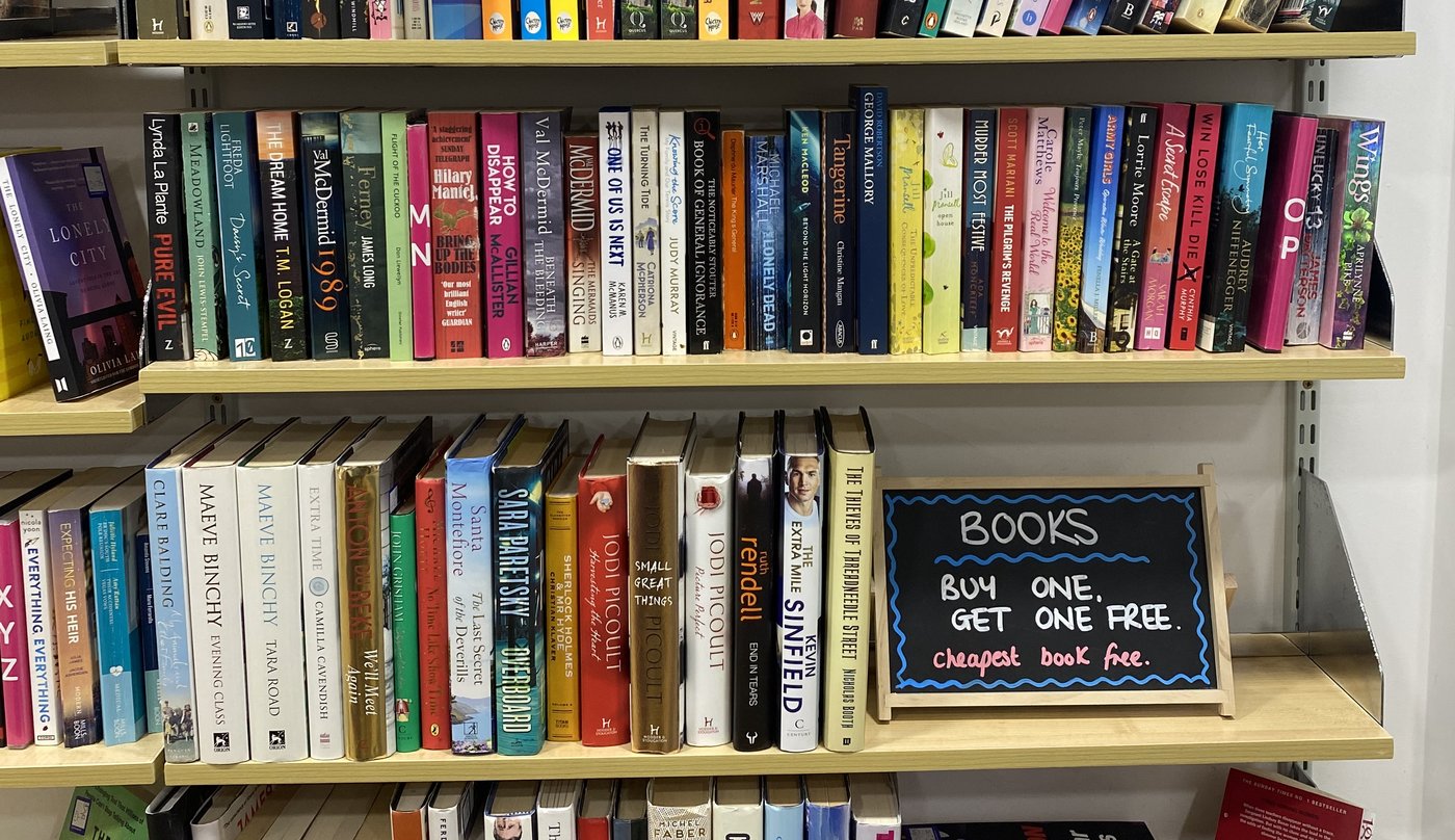 Charity shop bookshelf with three prize-winning books highlighted by Spines